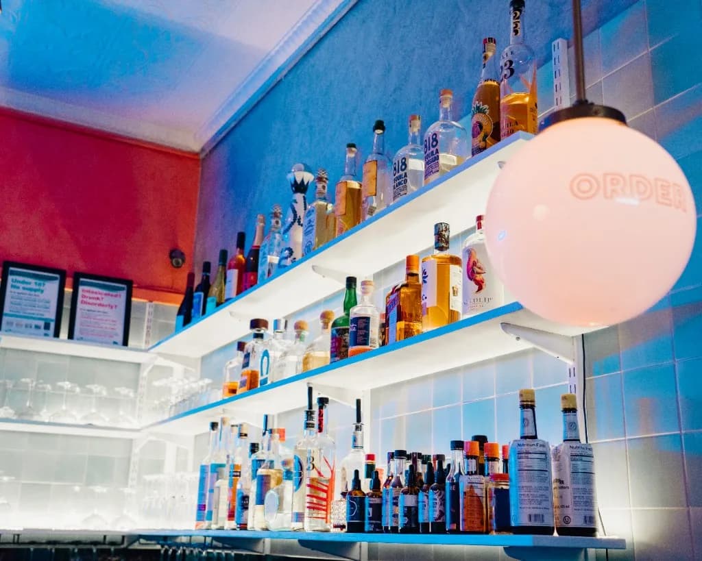 Backlit tequila shelves and ORDER globe lamp at Superchido agave bar