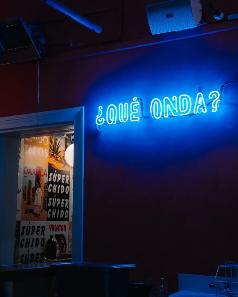 Blue neon ¿Qué onda? sign and colourful Mexican murals inside Superchido in Seddon