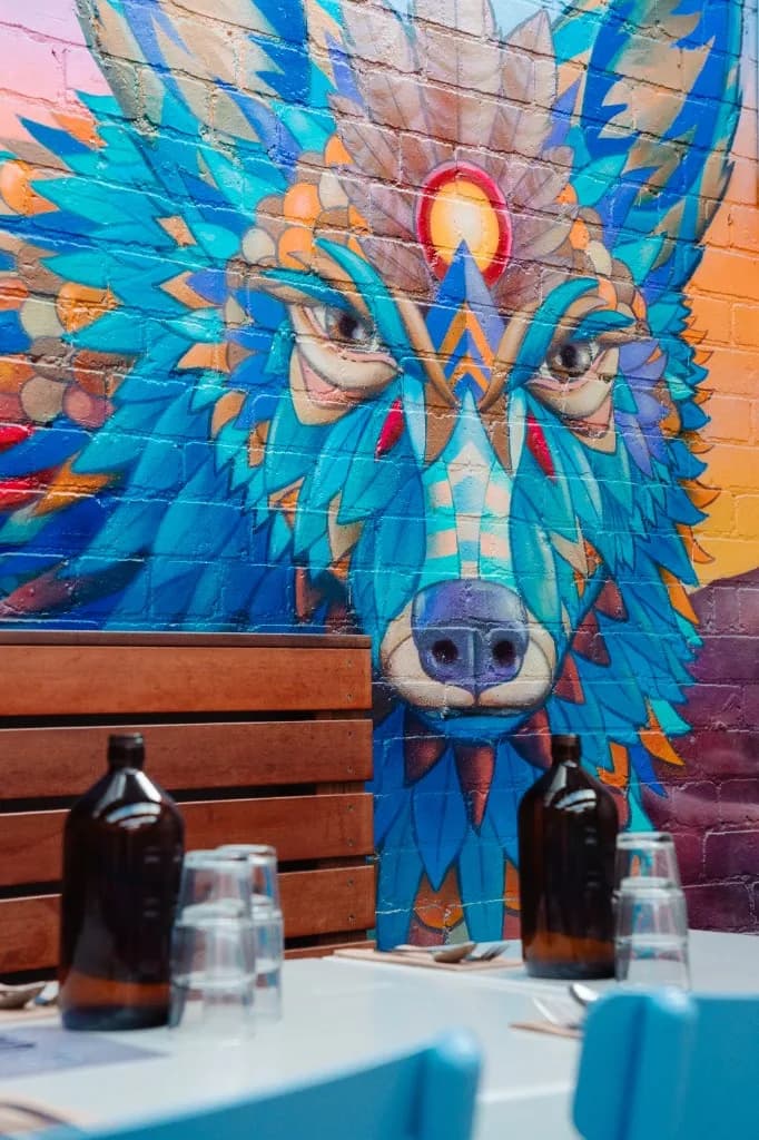 Sheltered patio dining with wolf mural at Superchido in Seddon